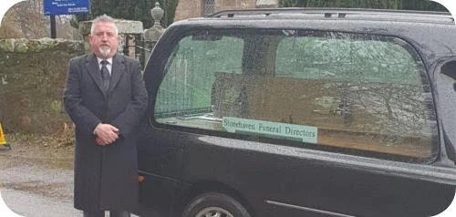 Mr William D Bruce (Billy) standing beside the hearse