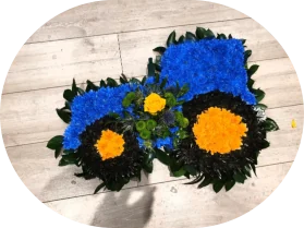 A tractor-shaped floral tribute in blue and yellow flowers