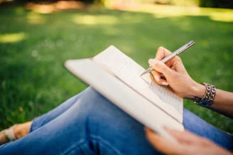 Writing in a notebook outdoors